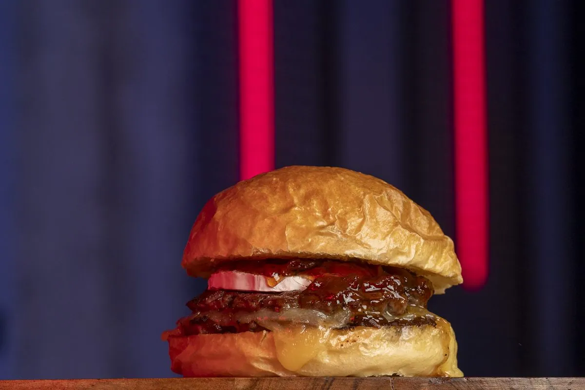 Hamburguesa La Goat: doble carne, queso monterrey, coronada con un medallón de queso de cabra y mermelada de pimientos asados