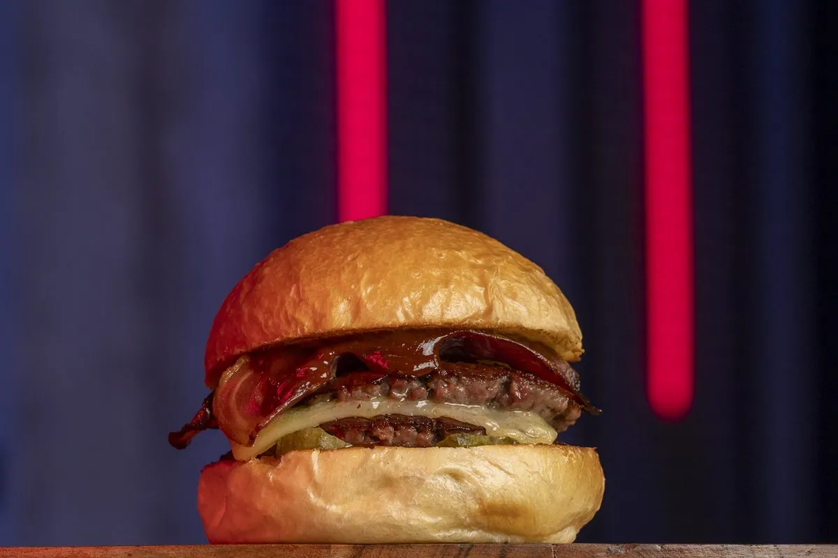 Hamburguesa La Smokey: doble carne, queso cheddar ahumado, bacon ahumado, pepinillos y salsa BBQ Bull's Eye